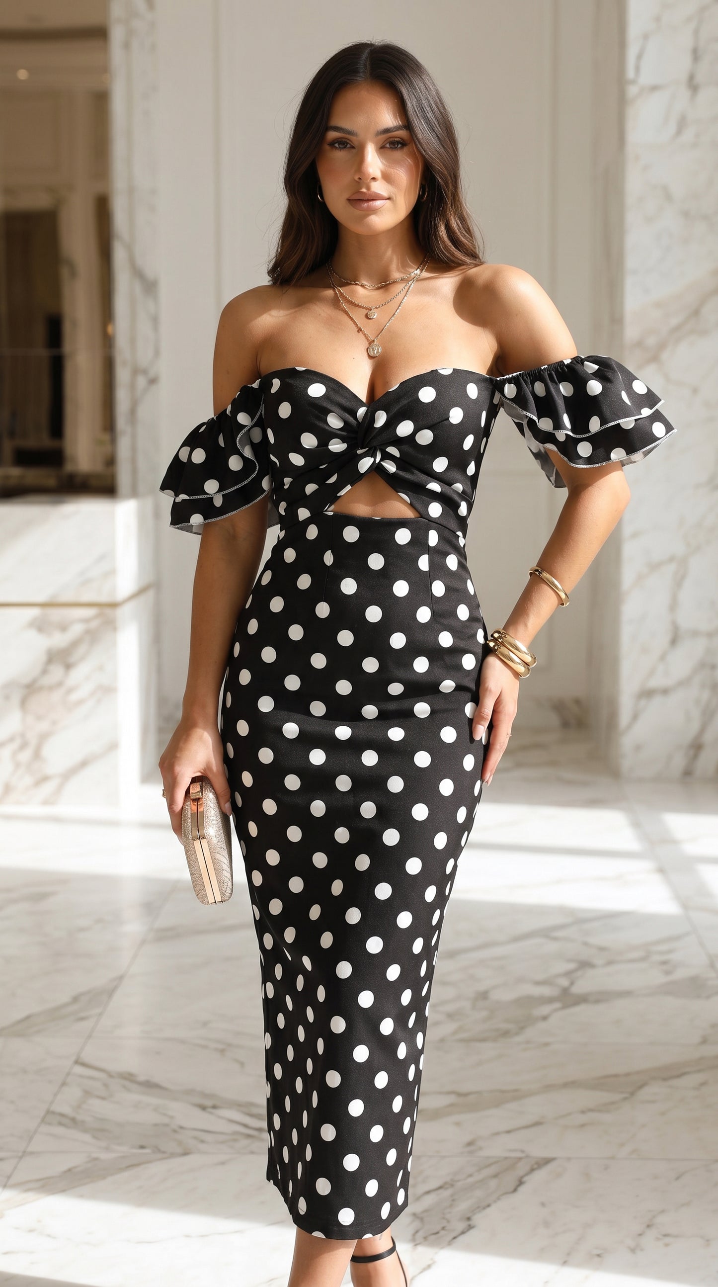 Woman wearing a black polka dot dress in an indoor setting